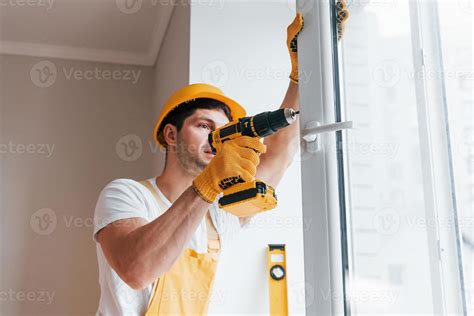 Faz Tudo Em Uniforme Amarelo Instala Nova Janela Usando Chave De Fenda