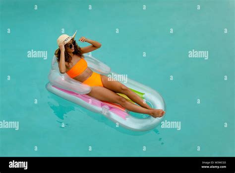 Woman In Bikini Relaxing On A Inflatable Tube In Swimming Pool At The