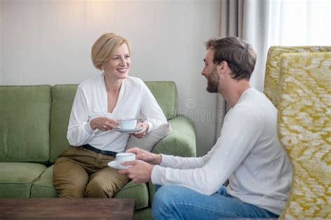 Blonde Woman And Her Son Sitting On The Sofa And Having Tea Stock Photo Image Of Morning
