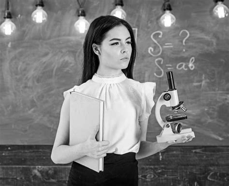 Lady Scientist Holds Book and Microscope, Chalkboard on Background ...