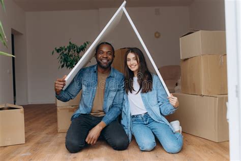 A Couple Moving Into Their Own House Gesture Of The Roof Of The House