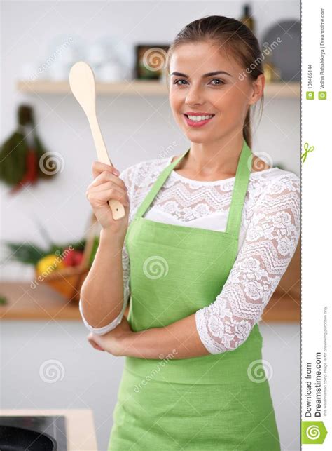 Young Woman In The Green Apron Is Cooking In The Kitchen Housewife Thinking About The Menu