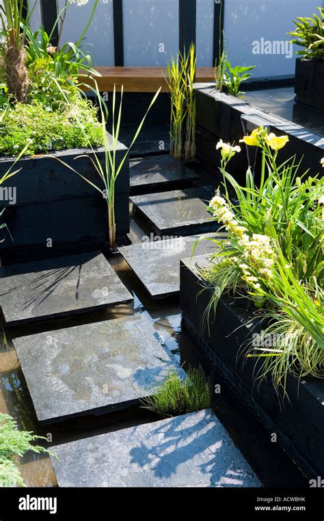 Black Slate Stepping Stones Through A Garden Water Feature Stock Photo