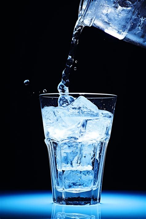 A Glass Of Ice Water Being Poured Background Wallpaper Image For Free