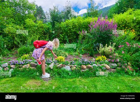 Une Jeune Fille Blonde Dans Une Robe Rose Avec Un Sac Dos Rouge Sur Son Dos Et D Un T L Phone