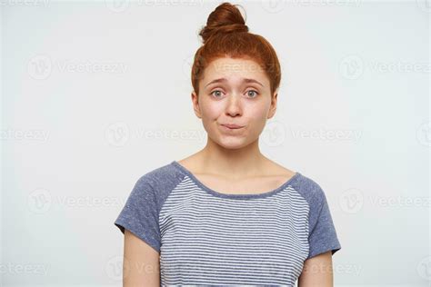 Bewildered Young Lovely Redhead Woman With Casual Hairstyle Biting Underlip And Wrinkling