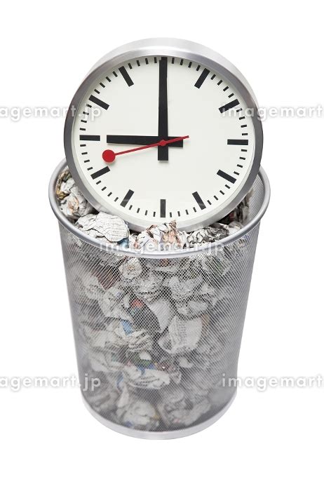 Clock In Wastebasket Full Of Crumpled Paper Over White Background