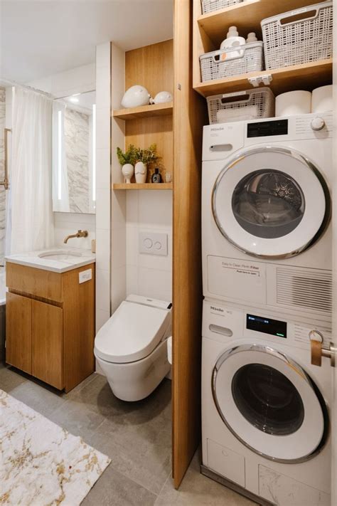 A Washer And Dryer In A Bathroom With Wooden Shelves Above The Toilet Bowl