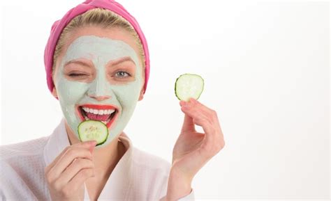 Premium Photo Woman With Mask On Face Eats Cucumber Beauty Treatments