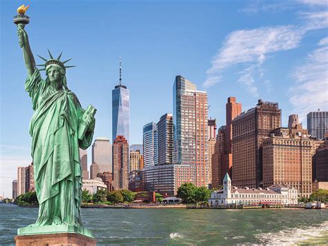 Cityscape Of The Statue Of Liberty In Front Of The Manhattan Skyline In