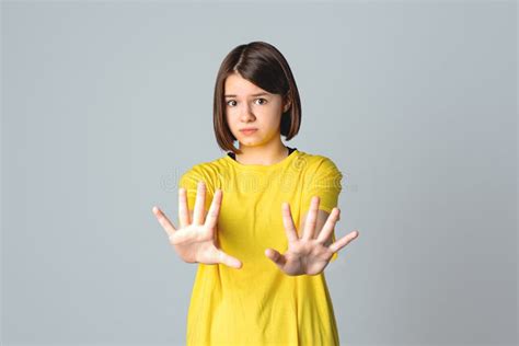 Portrait Of A Pretty Teen Girl Showing Zip Gesture As If Shutting Mouth