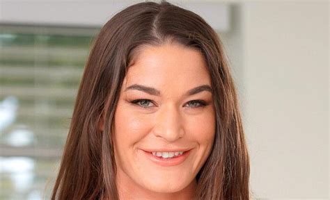 A Woman With Long Brown Hair Smiling At The Camera