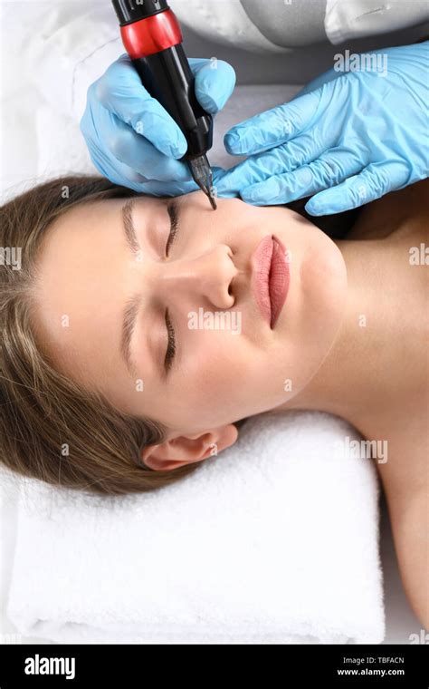 Young Woman Undergoing Procedure Of Permanent Makeup In Beauty Salon