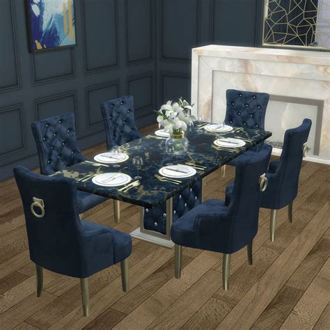 A Dining Room Table With Blue Chairs And White Plates On The Dinner