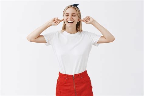 Insouciante Souriante Jeune Fille Blonde Posant Contre Le Mur Blanc