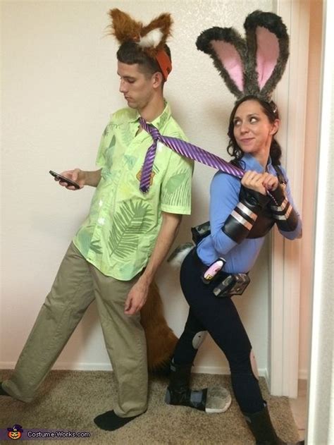 A Man And Woman Dressed Up As Bunny Ears One Holding A Camera While The Other Holds A Cell Phone