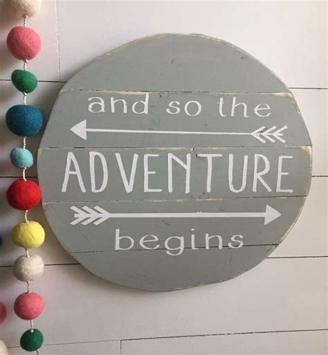 A Wooden Sign That Says And So The Adventure Begins With Pom Poms