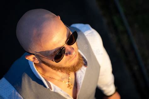 Bold Guy With A Stylish Beard And Sunglasses On A Sky Background During
