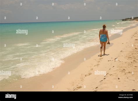 A Woman Walks Along A Beach In Playa Del Carmen Mexico Stock Photo Alamy