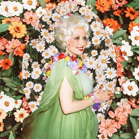 A Woman In A Green Dress Surrounded By White And Orange Flowers With