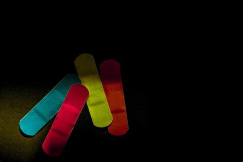 Premium Photo Close Up Of Colorful Bandages On Black Background