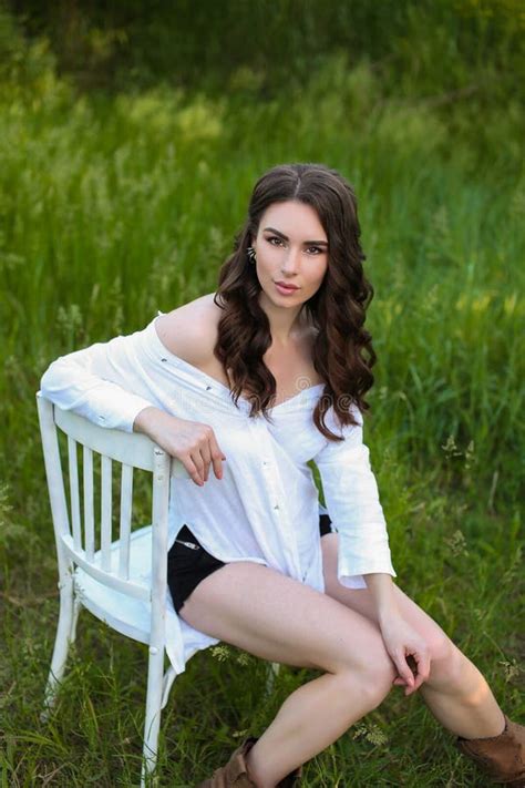 A Strict Beautiful Natural Brunette Girl In A Bright White Room Is