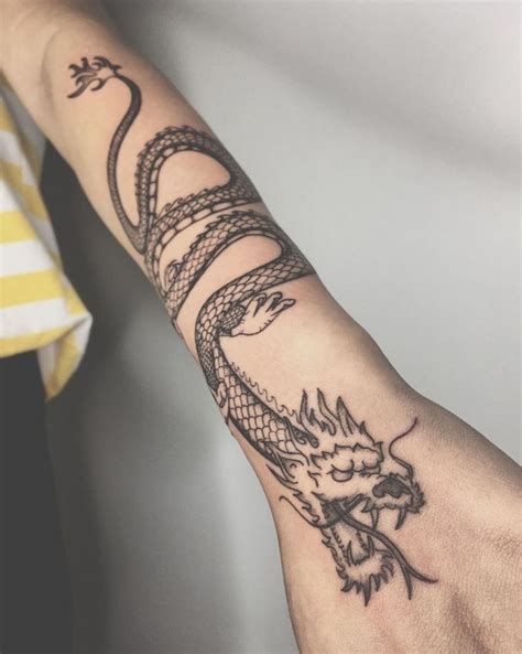 A Person S Arm With A Tattoo On It And A Dragon On The Wrist