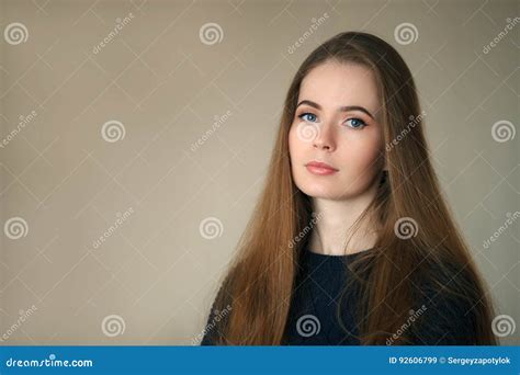 Indoor Headshot Of Happy Natural Looking Beautiful Woman In Dark Blue Sweater Beige Background