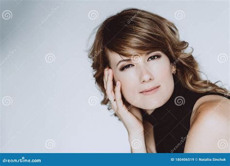 Portrait Of A 36 Year Old Woman With Curly Hair And Brown Slanting Eyes