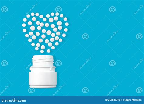 Heart Shaped White Medical Pills On A Blue Background Tablet Stock