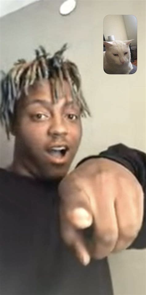 A Man With Dreadlocks Pointing At The Camera While Wearing A Black T