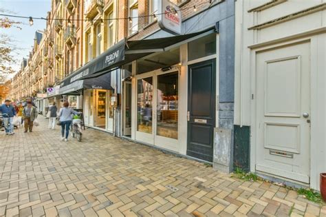 Premium Photo People Walking Down A Street In Front Of A Store