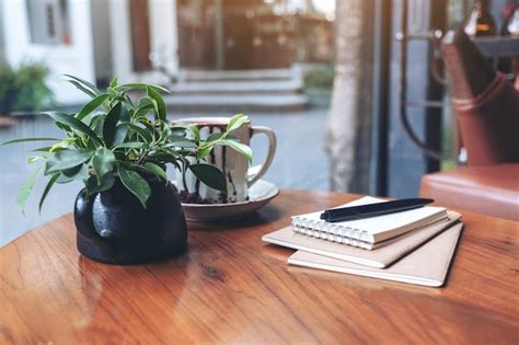 Premium Photo Notebooks Pen And Coffee Cup On Wooden Table