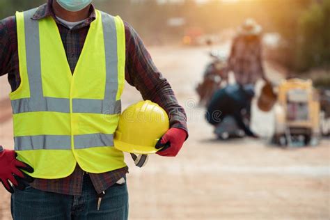 Worker in Uniform Holding Helmet in the Road Construction Stock Photo ...