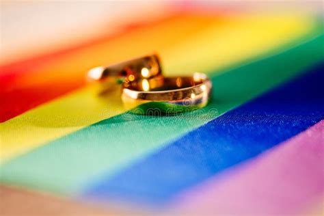 Two Gold Wedding Rings On Rainbow Lgbt Flag Homosexual Marriage Stock