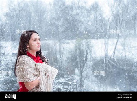 Attractive Young Woman With Long Dark Hair In A Red Dress Covered By A Handmade Shawl Smiling