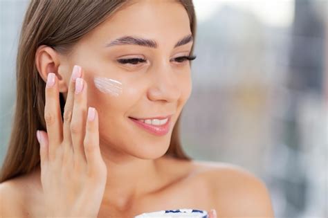 Premium Photo Girl Applying Moisturizing Cream On Her Face