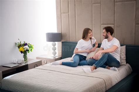 Happy Couple Sitting on Bed in Cozy Stock Image - Image of casual, lamp ...