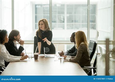 Jefe Serio De La Mujer Que Habla Con El Equipo Multirracial En La