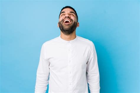 Jovem Latina contra uma parede azul relaxado e feliz rindo pescoço esticado mostrando os
