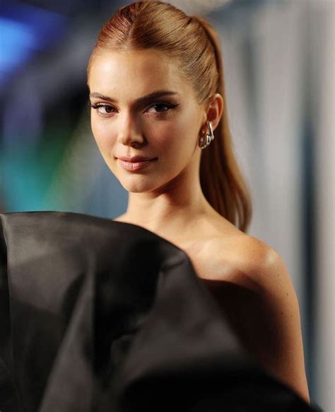 A Woman With Very Long Hair In A Ponytail And Wearing Earrings On Her