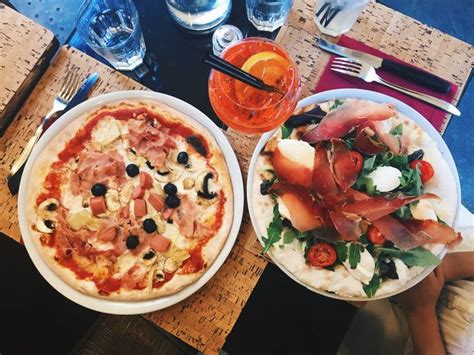 Two Plates With Pizza And Salad On Them