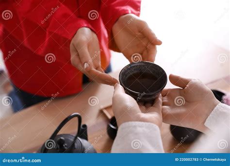 Master Giving Freshly Brewed Tea To Guest During Ceremony At Table