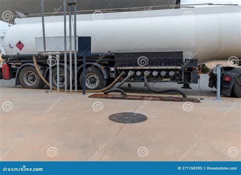 Fuel Tanker Truck Unloading At A Service Station With Two Hoses