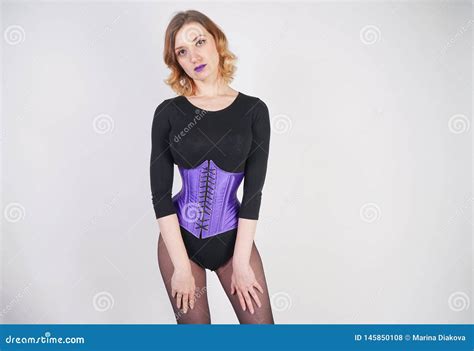 Jolie Fille Blonde La Mode Utilisant La Salopette Noire Avec Le Collant De Maille Et Le Corset