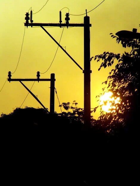 Silhueta de um pilar de eletricidade contra o céu durante o pôr do sol