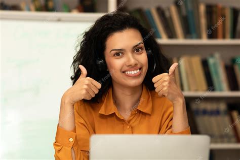 Premium Photo Online Teacher Happy Mixed Race Female Tutor In Headphones Showing Thumbs Up