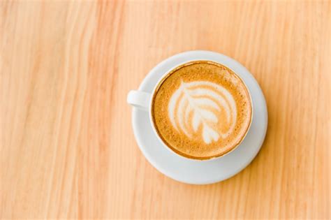 Une Vue De Dessus De Café Cappuccino Avec Latte Art Sur Table En Bois