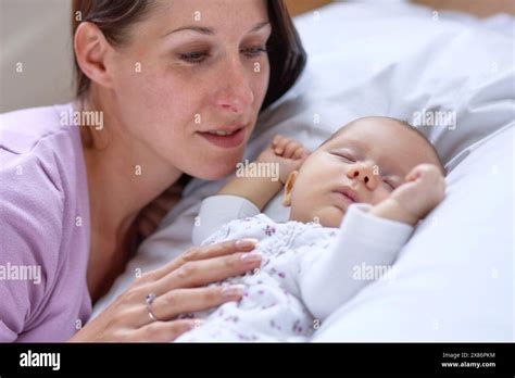 Baby Sleeping Next To Mother Stock Photo Alamy