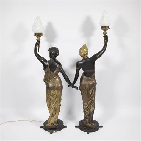 Lot - 2 imposing statues in bronze and gilt bronze of Venetian ladies, each carrying a torch as ...